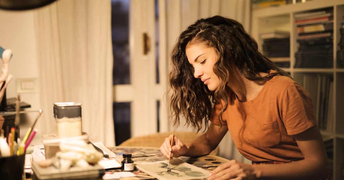 young-woman-painting-on-paper-at-workplace